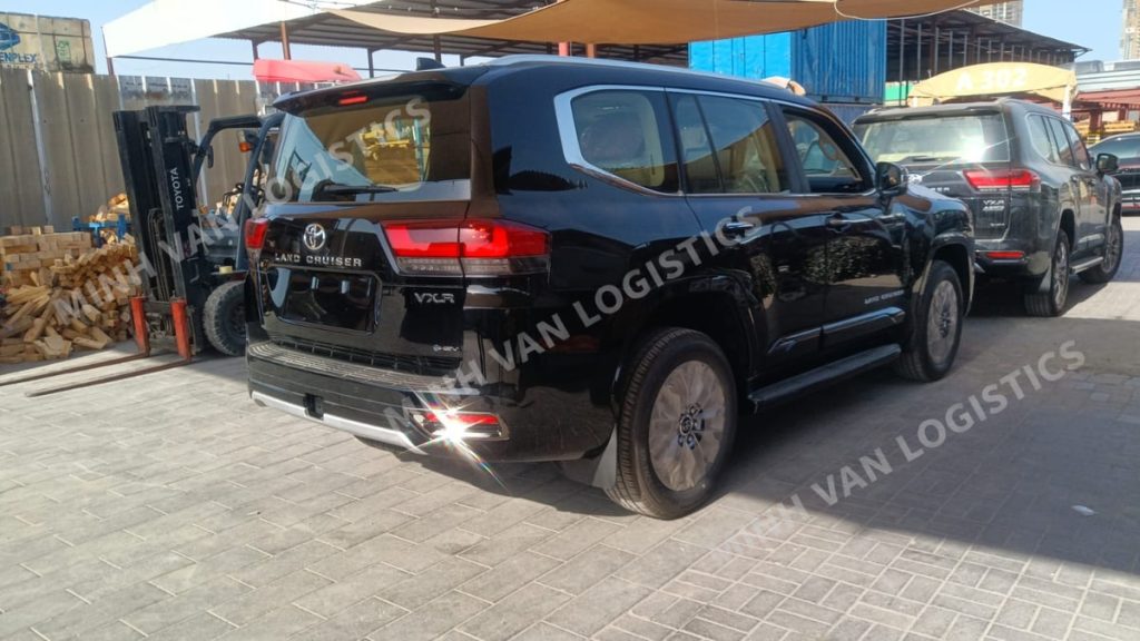 Toyota Land Cruiser màu đen tại bãi, nhìn từ phía sau và bên hông xe.